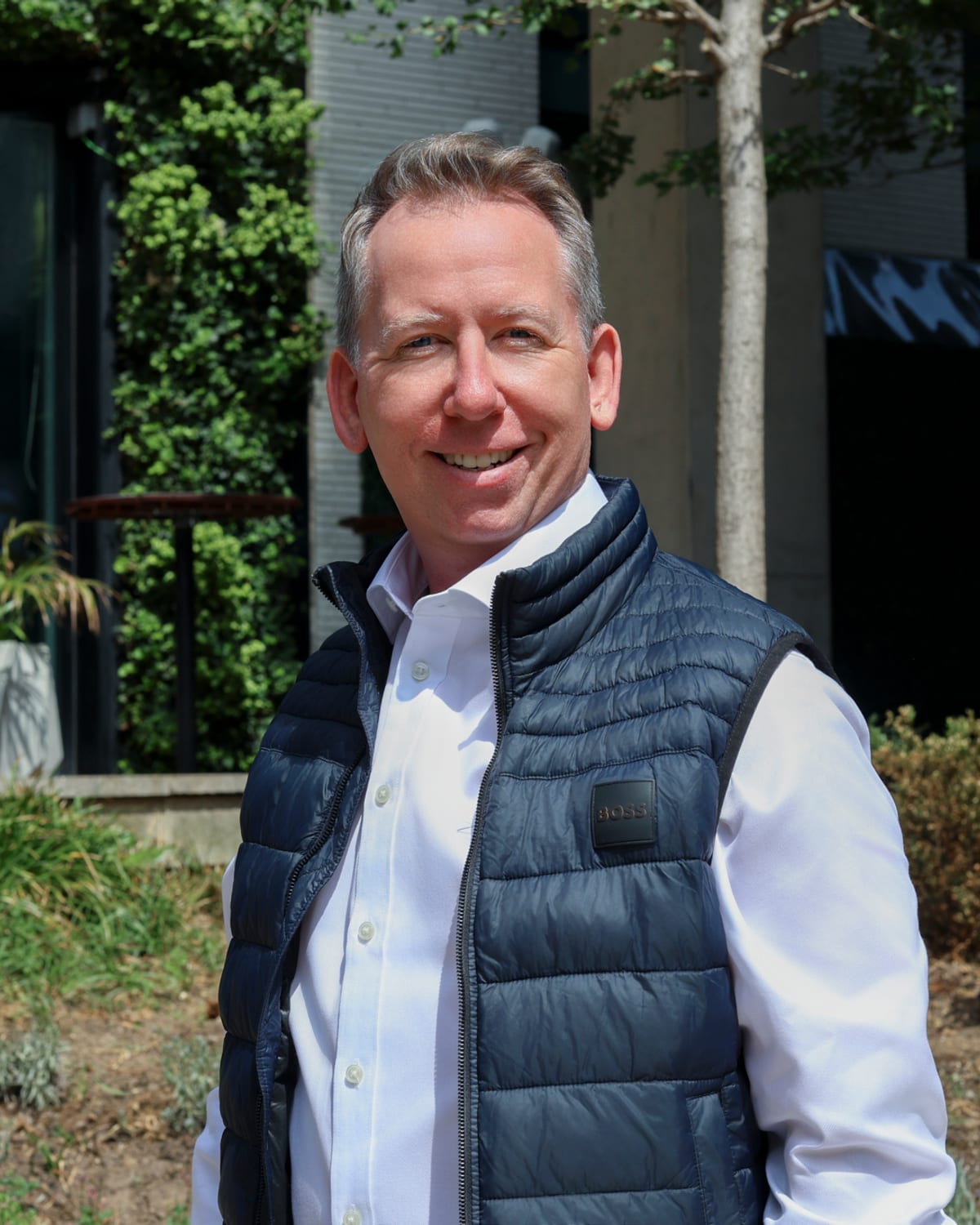 John Margerison outside an office building, smiling