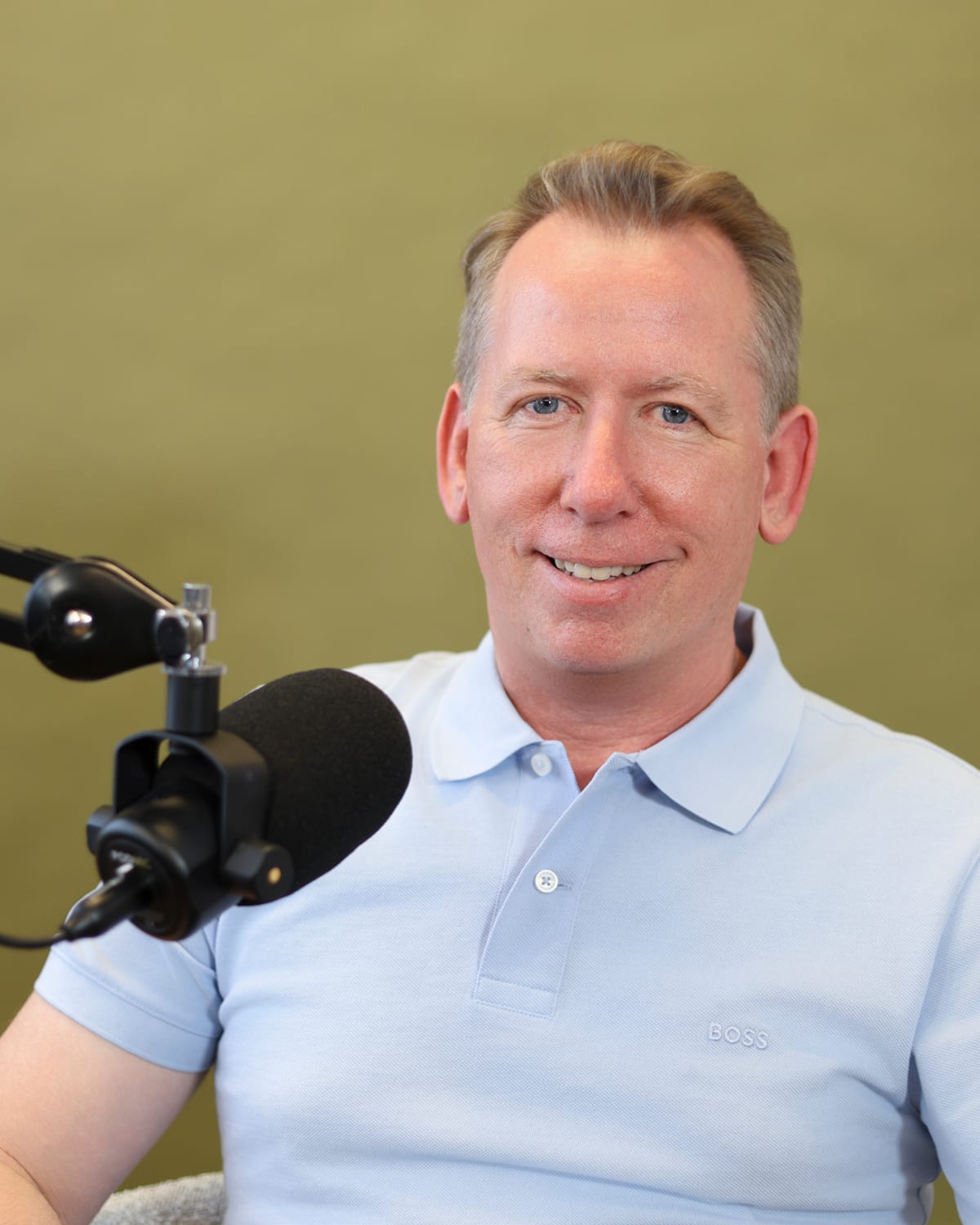 John Margerison recording a podcast, at the microphone